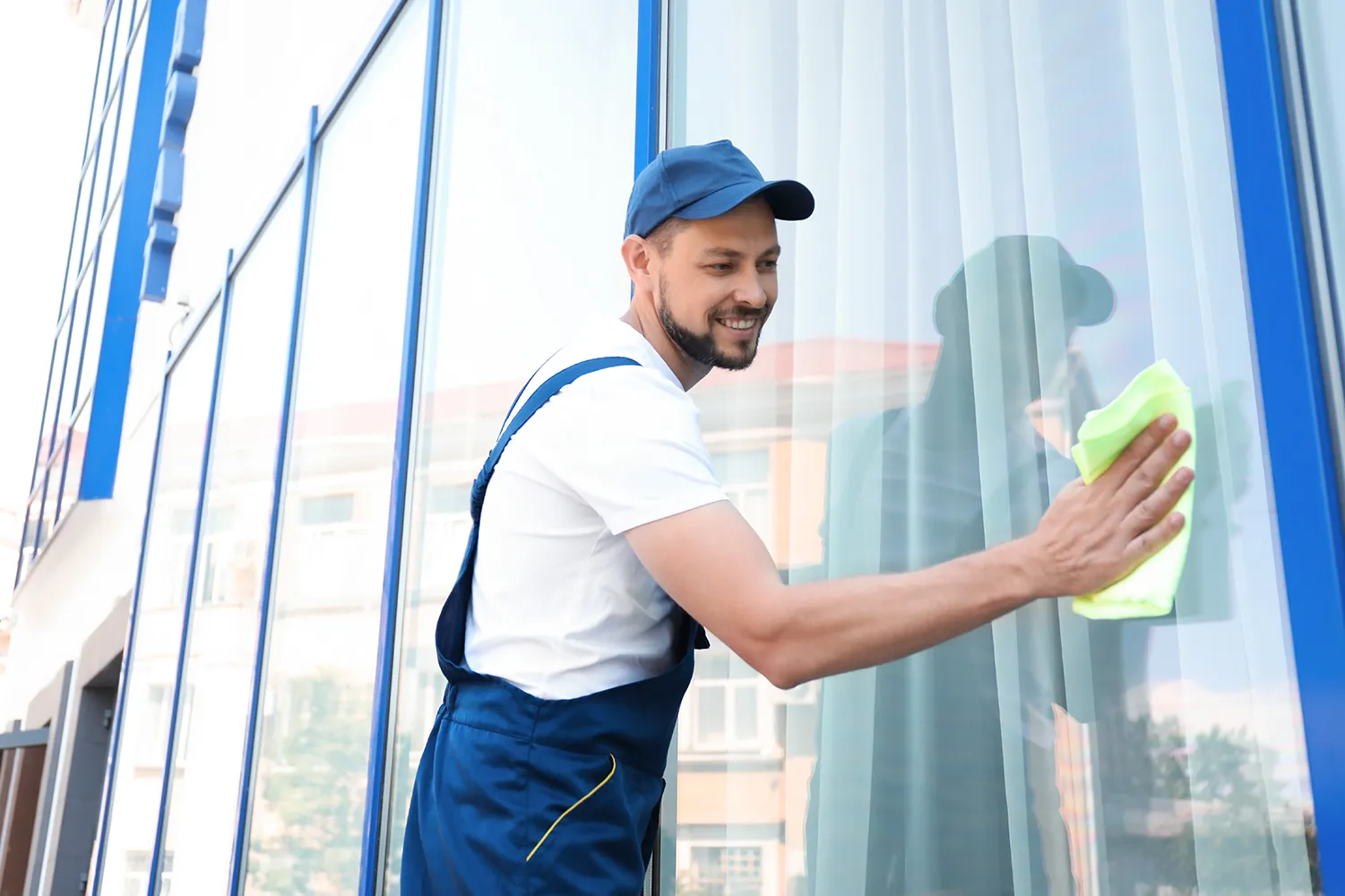Top Clean Crew - Arbeiter beim Reinigen von Fensterglas
